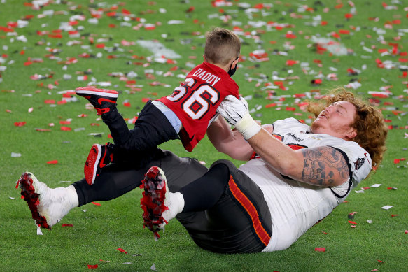 Ryan Jensen celebrates with his child after defeating the Kansas City Chiefs in Super Bowl LV. 