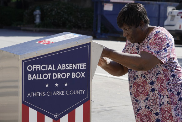 A voter drops her ballot off during early voting on Tuesday AEDT in Athens, Georgia, US.
