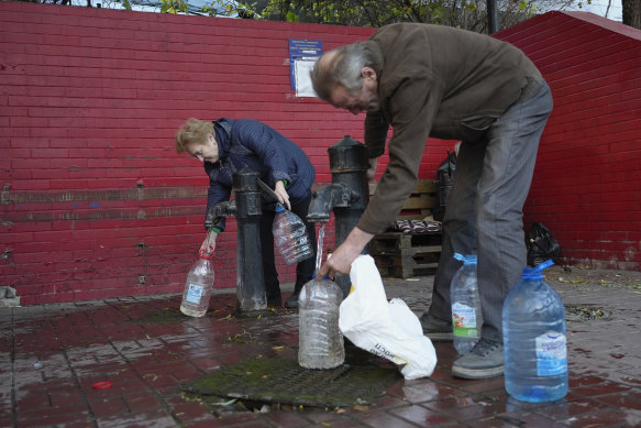 People fill containers with water from public water pumps in Kyiv, Ukraine, on Monday.