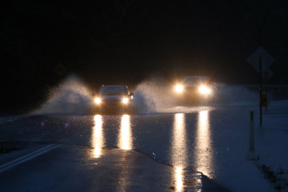 Two drivers take their chances in floodwaters at Old Bar near Taree.   