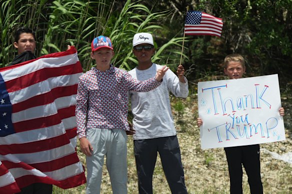 La gente saluda cuando Donald y Melania Trump pasan en una caravana en Kerrville, Texas.