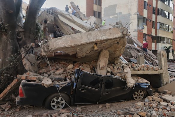 A vehicle is crushed by debris after the earthquake struck Cali, Colombia, on Monday.