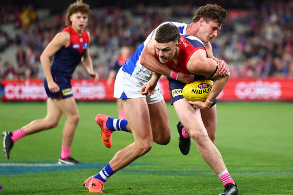 Daniel Turner of the Demons is tackled by Charlie Comben of the Kangaroos.
