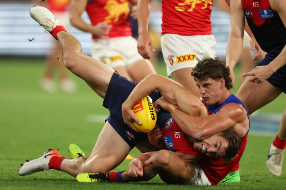 Jack Viney of the Demons tackled by Jarrod Berry of the Lions.