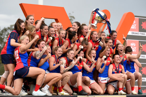 Demons players celebrate on stage after winning the 2022 grand final. 