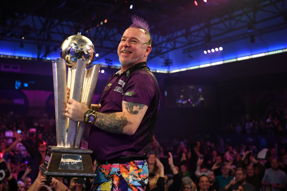 Peter 'Snakebite' Wright lifts the Sid Waddell trophy after seeing off  Michael van Gerwen in the world championship final.