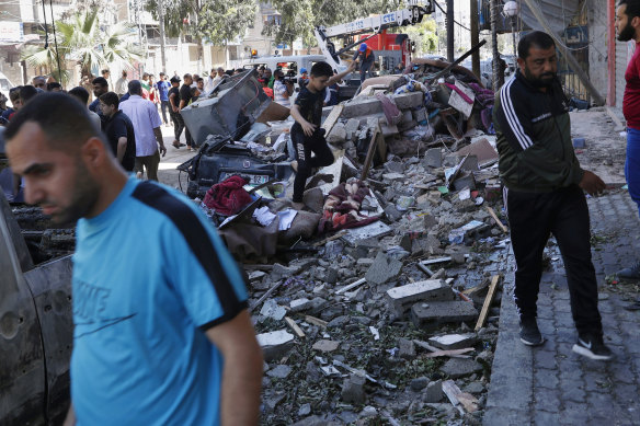 People in Gaza City inspect the rubble of the Abu Hussein building that was hit by an Israeli air strike early on Wednesday morning. 