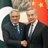 Chinese Foreign Minister Wang Yi, right, poses for photos with Pakistani Deputy Prime Minister and Foreign Minister Mohammad Ishaq Dar in Beijing.