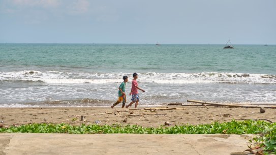 People walk along Citepus Beach, Palabuhan Ratu, Indonesia.