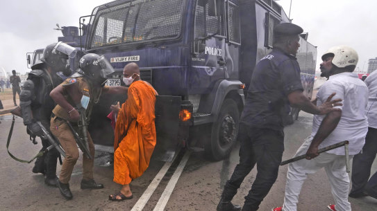 Supporters of Sri Lankan government attempt to block a police water canon truck during a clash with anti-government protesters in Colombo, Sri Lanka, Monday, May 9, 2022.