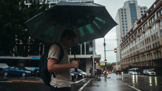 WET WEATHER: Storms, Heavy rainfall, floods, flooding, deluge, umbrellas, rugged up, rain, wet, water.  Sydneysiders brace heavy rainfall, Sydney CBD, Friday  5th of April 2024. Photo: Dion Georgopoulos / The Sydney Morning HeraldP