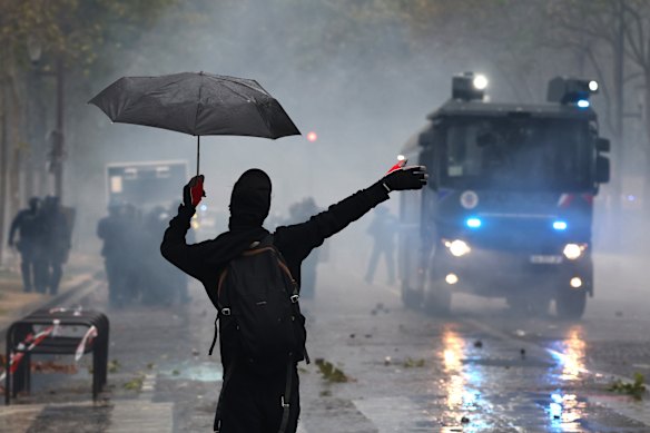A protester stands amidst tear gas during demonstrations in Central Paris, France. The French high school protests and riots have entered a new phase this week as student and teacher unions mobilise for a massive nationwide day of action aimed at forcing systemic changes after rejecting the government’s emergency offer of 3,000 substitute teachers.