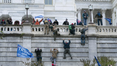 Trump supporters scaling the wall of the US Capitol. The attack on the Capitol resulted in the death of five people.
