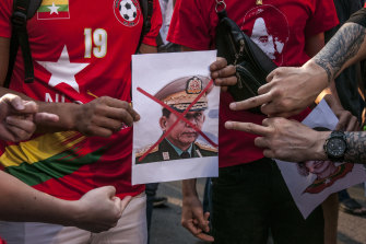 Supporters of Suu Kyi’s National League for Democracy point to a crossed-out portrait of Myanmar’s army chief, Min Aung Hlaing, at a protest in Bangkok on February 1.