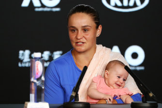 Ashleigh Barty holds niece Olivia while speaking to the media after the match.