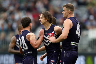 Nat Fyfe of the Dockers celebrates with Lachie Schultz and Sean Darcy after kicking a goal.