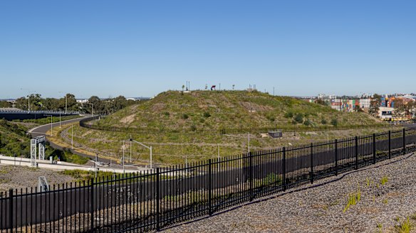 The fenced-off hill at the south-western end of the motorway interchange dominates the area.