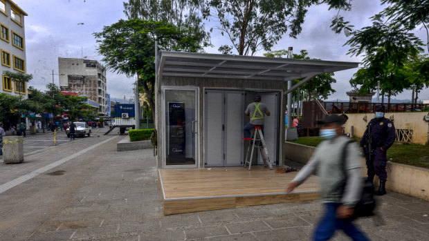 A worker installs a Chivo Bitcoin automated teller machine booth at Gerardo Barrios plaza in San Salvador.