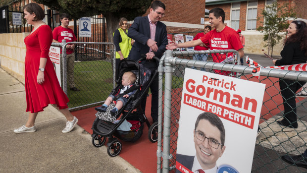 Labor candidate for Perth Patrick Gorman leaves the Highgate polling station alongside his wife Jess and their son Leo on election day.