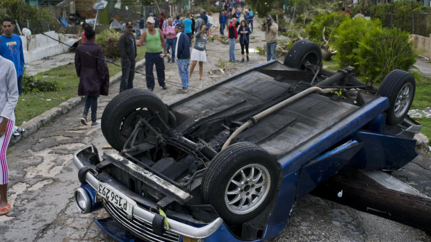 A car overturned by the tornado lays smashed on top of a street pole in Havana.