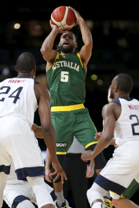 Patty Mills rises above USA's defence to fire off a shot for Australia.