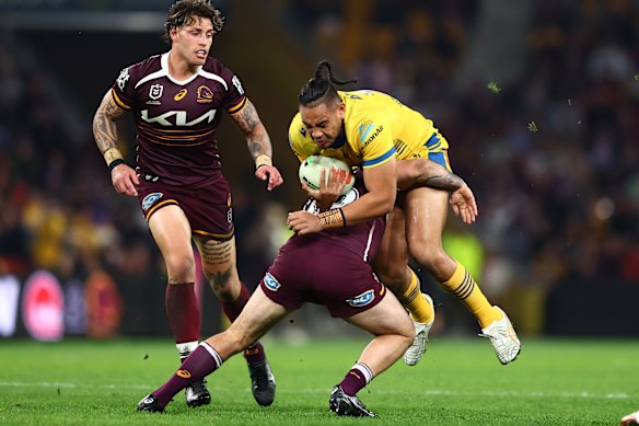 Sam Tuivaiti charges into a Broncos tackler.