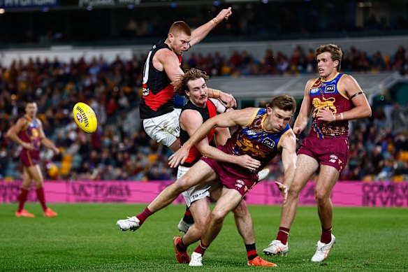 Peter Wright of the Bombers, Dyson Sharp of the Bombers and Harris Andrews of the Lions compete for the ball.