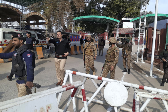 Ordu askerleri ve polis memurları, Pakistan'ın Peşaver kentindeki bomba patlama alanına doğru koşan ambulansların önünü açıyor.