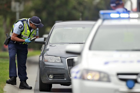 A police officer conducts a random breath test.