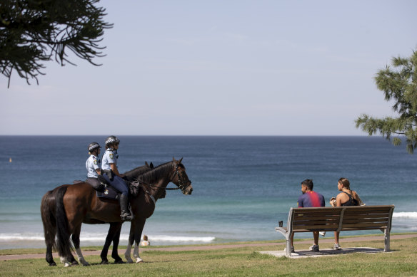 Mounted police at Bondi Beach question beach goers why they are not following new social distancing rules.