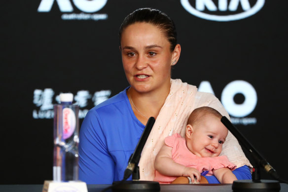 Ashleigh Barty holds niece Olivia while speaking to the media after being knocked out of the Australian Open.