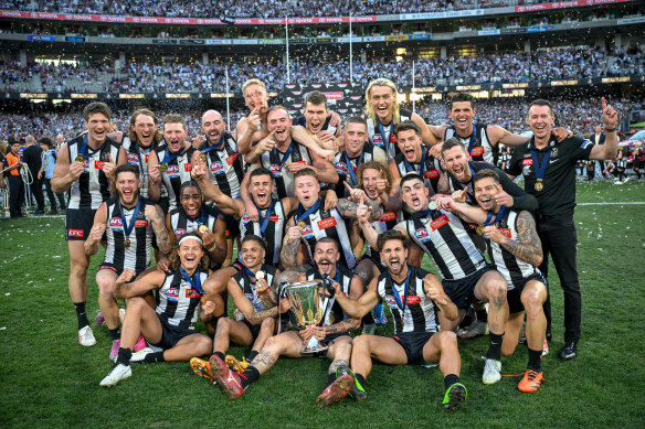 Collingwood pose with the 2023 premiership cup on grand final day – which Matt and Zak will never forget.