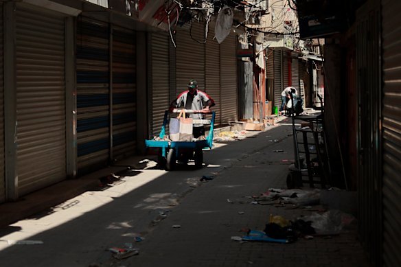 A street vendor pushes his cart an almost empty market during a curfew to help fight the spread of the coronavirus, in Baghdad, Iraq.