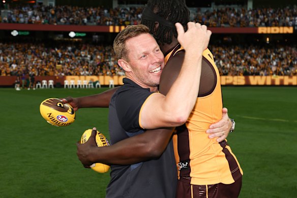 Mabior Chol and coach Sam Mitchell embrace after their win. 