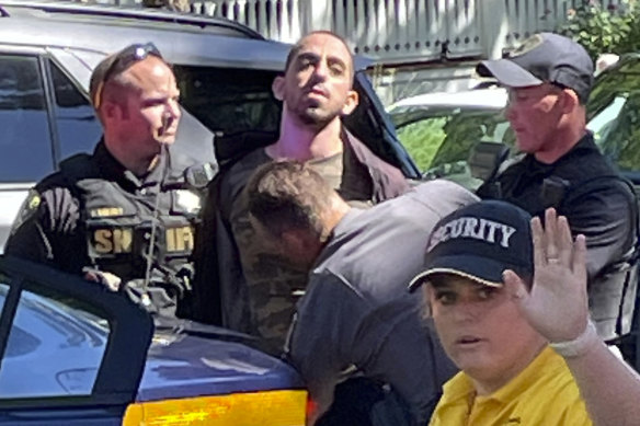 Law enforcement officers detain Hadi Matar, centre, following the stabbing of Salman Rushdie.