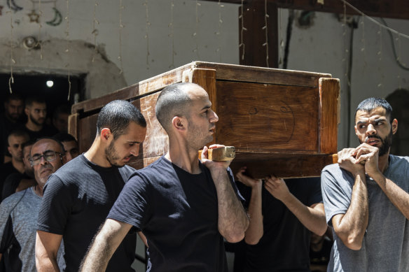 Mourners carry the coffin of Israeli Arab Khalil Awaad and his daughter Nadine,16,  during their funeral in the village of Dahmash near the mixed Israeli city of Lod.