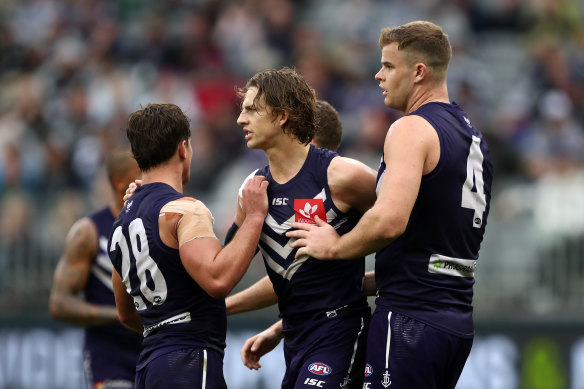 Nat Fyfe of the Dockers celebrates with Lachie Schultz and Sean Darcy after kicking a goal.