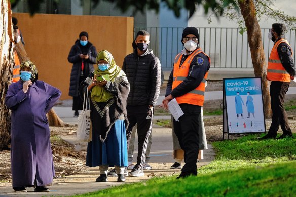 Residents from the Flemington public housing towers at 130 Racecourse Road queue at a makeshift COVID-19 testing centre on Saturday. 