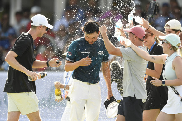 Min Woo Lee is sprayed with champagne on the 18th green.