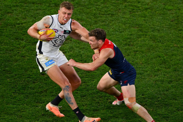 Patrick Cripps attempts to fend off Jack Viney.