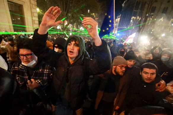 Protesters shout in front of police line as they pour into the streets following Georgian Prime Minister Irakli Kobakhidze’s announcement, rallying outside the parliament building in Tbilisi, Georgia.