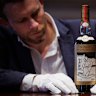 Jonny Fowle, Sotheby’s global head of spirits, unveils a bottle of The Macallan 1926, the world’s most expensive whisky.
