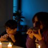 A family eats by candlelight during the blackout in Barcelona.