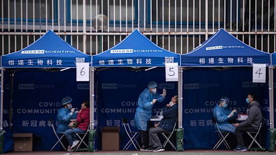 People receive COVID-19 PCR tests at a testing facility in the Tuen Mun area of Hong Kong.