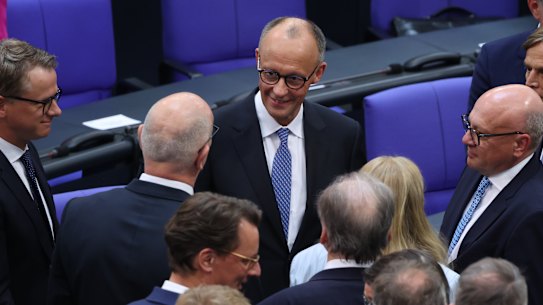 Friedrich Merz of the German Christian Democrats (CDU) is congratulated by colleagues after he won in a second vote in his election as German chancellor.