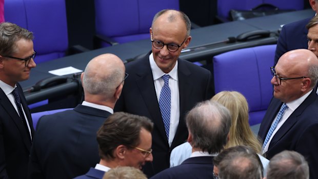 Friedrich Merz of the German Christian Democrats (CDU) is congratulated by colleagues after he won in a second vote in his election as German chancellor.