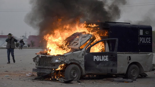 A police vehicle burns following the clashes between police and the supporters of former prime minister Imran Khan, at outside the court, in Islamabad, Pakistan, on Saturday.