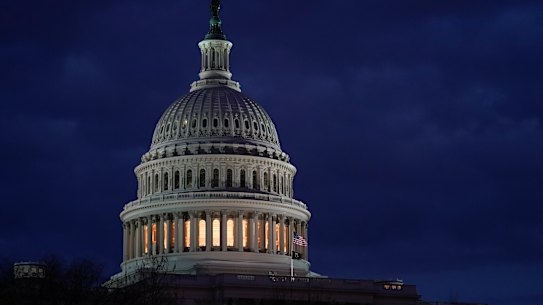 Light shines from the US Capitol dome after sunset.