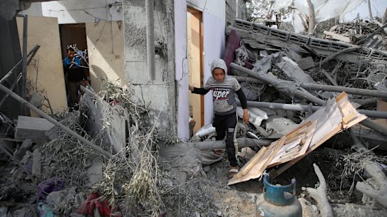 Palestinian children inspect the ruins of a residential building for the Abu Muammar family after an Israeli airstrike in Rafah, southern Gaza Strip, 