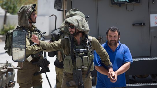 Israeli soldiers make one of several arrests of Palestinians after a soldier of their occupation force was killed by a rock thrown from a rooftop in the West Bank village of Yabad on Tuesday. 